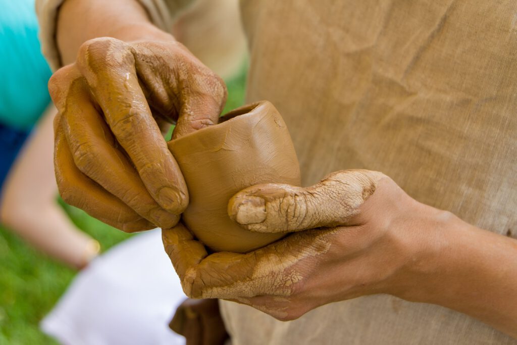 a man sculpts a mug from clay with his hands he 2022 11 16 18 18 38 utc 2